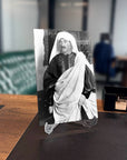 Black and white photo of a man dressed in traditional attire, displayed on a modern desk with an elegant background.